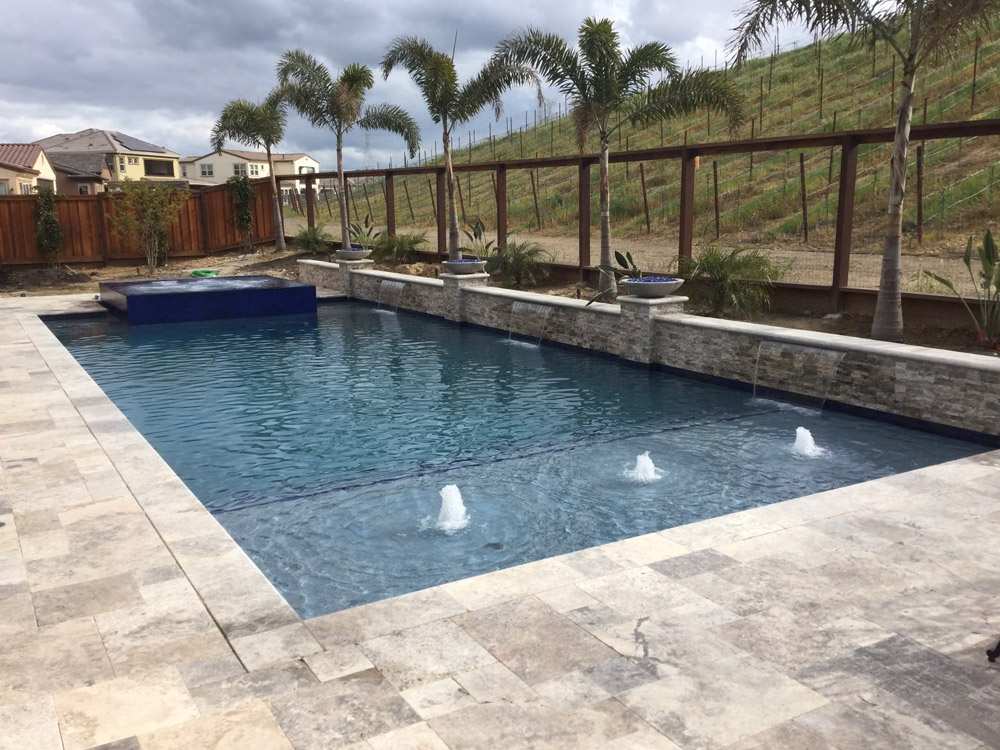 A swimming pool with a decorative fountain and inviting patio area in the East Bay & Bay Area