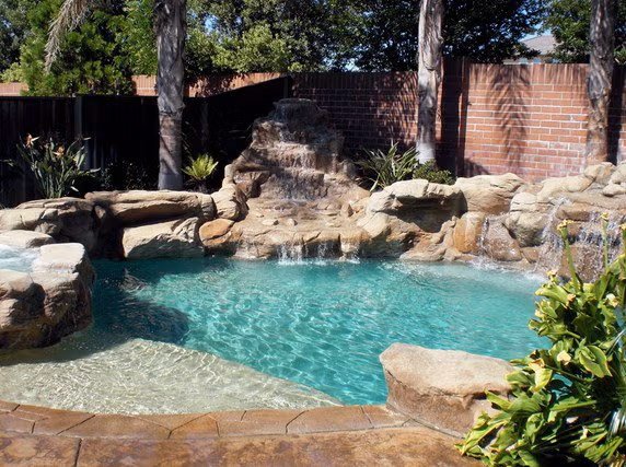 A Backyard Pool Featuring a Shallow Sun Shelf and Stone Waterfall Features in the Bay Area