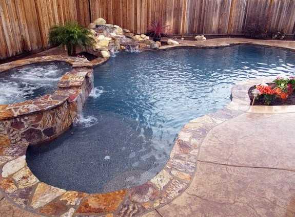 A Custom Freeform Swimming Pool with a Natural Stone Finish and an Attached Hot Tub in the Bay Area
