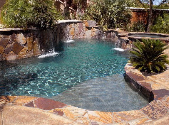 A Freeform Swimming Pool with Cascading Stone Waterfalls and a Shallow Sun Shelf in the Bay Area
