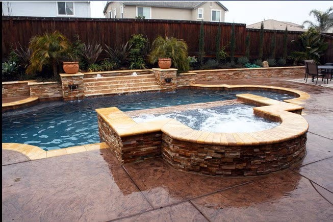 A Freeform Swimming Pool with a Raised Stone Spa and Natural Rock Landscaping in the Bay Area