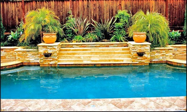 A Swimming Pool Enhanced by a Raised Stone Accent Wall and Cascading Water Features in the Bay Area
